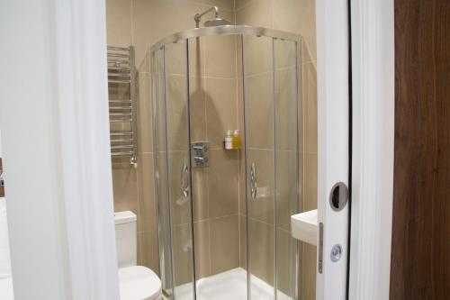 a bathroom with a shower with a toilet and a sink at Chelsea Guest House in London