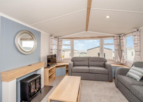 a living room with a couch and a table at Ladram Bay Holiday Park in Otterton