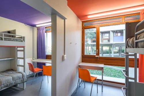 a room with a bunk bed and a table and chairs at Centre International de Séjour André Wogenscky in Saint-Étienne