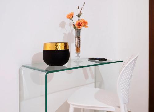 a glass table with a vase with flowers on it at Quintessenza- Luxury Suites in Leverano
