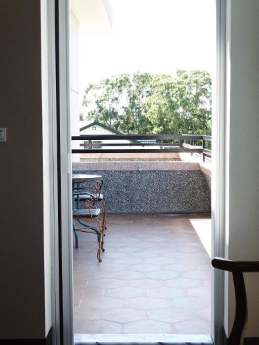 an open door to a balcony with a table and chairs at Ikegami Dapo Moutain Bed and Breakfast in Chishang