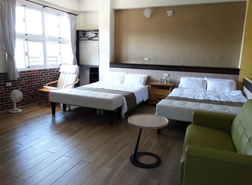 a hotel room with two beds and a couch at Ikegami Dapo Moutain Bed and Breakfast in Chishang