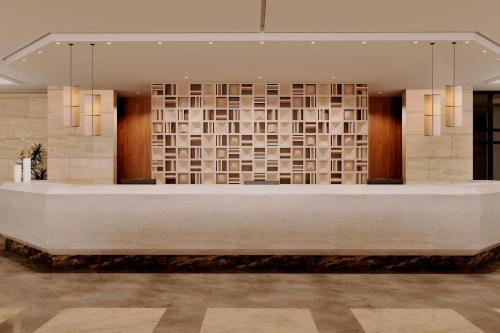 a hotel lobby with a large white reception desk at Sheraton Rhodes Resort in Ixia