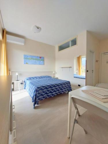 a bedroom with a bed and a table in it at Residence La Palma in Marina di Andora