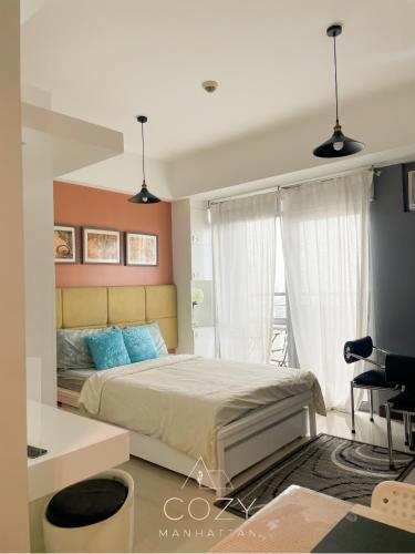 a bedroom with a large bed with blue pillows at Studio Unit in Manhattan Heights with Balcony in Sampong