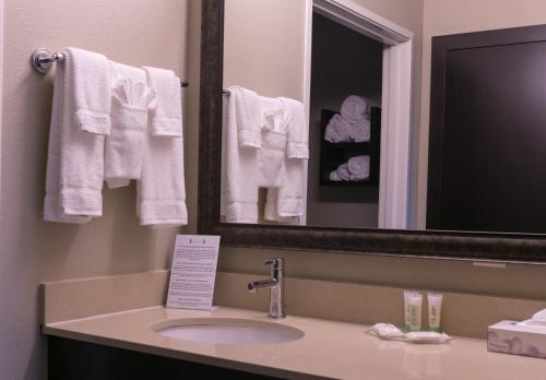 ein Badezimmer mit einem Waschbecken, einem Spiegel und Handtüchern in der Unterkunft Staybridge Suites Austin North - Parmer Lane, an IHG Hotel in Austin