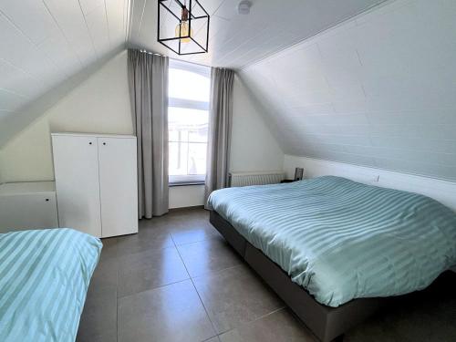 a bedroom with two beds and a window at Hof ter Eversam in Alveringem