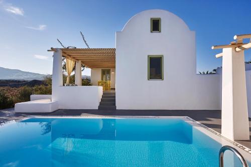 a villa with a swimming pool in front of a house at Villa Agrikoia in Oia