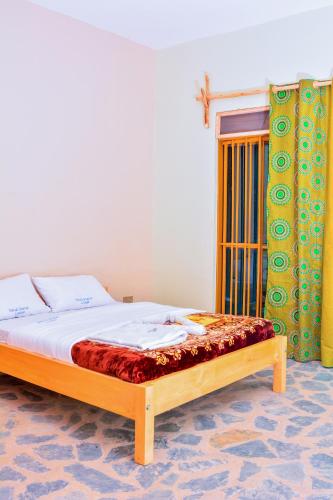 a bedroom with a bed and a window at Bwindi Breeze Lodge in Kisoro