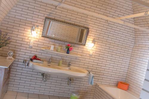 a bathroom with two sinks and a white brick wall at Kuschelige Ferienwohnung in Schwandorf in Bayern