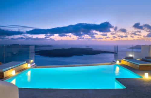 a swimming pool with a view of the ocean at night at Villa Ioli Anastasia in Firostefani