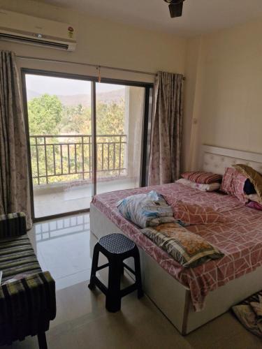 a bedroom with a bed and a large window at Anwesha's Home Stay Alibaug in Alibaug