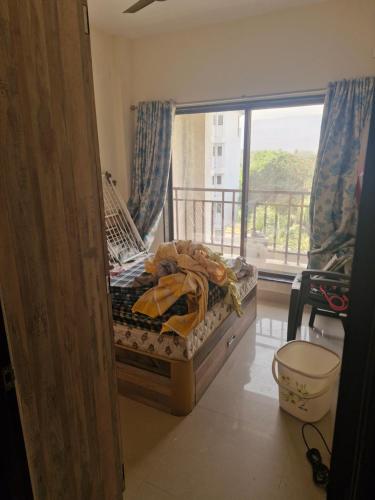 a small bed in a room with a balcony at Anwesha's Home Stay Alibaug in Alibaug
