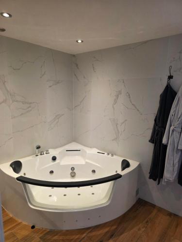 a white bath tub in a room with marble walls at B&B Driel in Driel