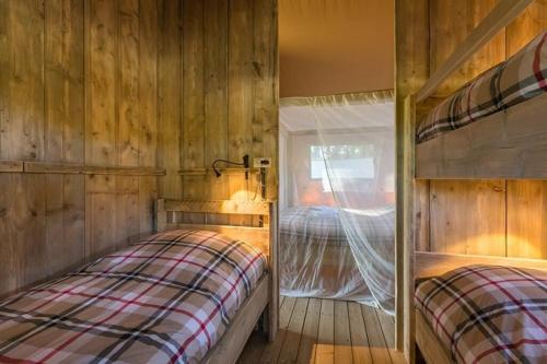 a bedroom with two bunk beds and a window at Village de Montmarsis in Gourdon