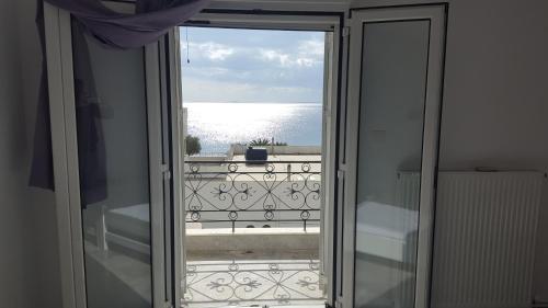 a door to a balcony with a view of the water at Varmy in Ierápetra