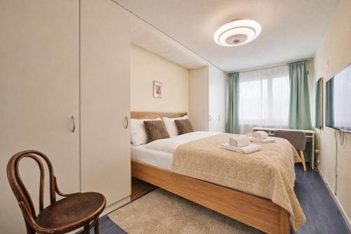 a bedroom with a bed and a chair and a window at Chalet in Thun, modern, spacious, perfect location in Thun