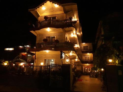 a large building with a balcony at night at Harvest Moon Guest House in Pokhara