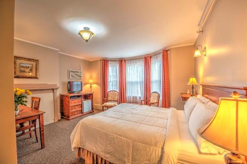 una camera con letto, scrivania e TV di The Sonata Inn a Charlottetown