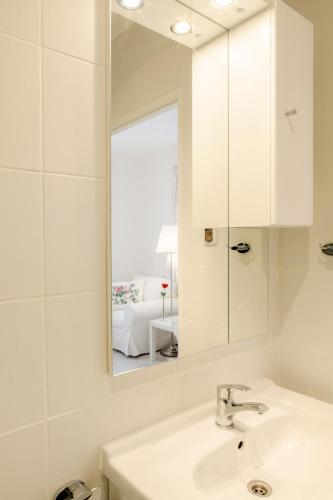 a white bathroom with a sink and a mirror at 4 Couples & 4 Friends Hostel in Krakow