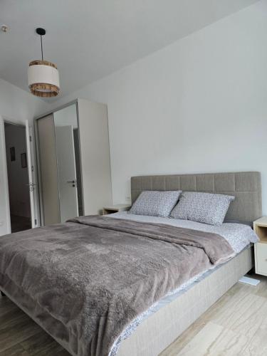 a bedroom with a large bed in a white room at Budva Central Escape Apartment in Budva