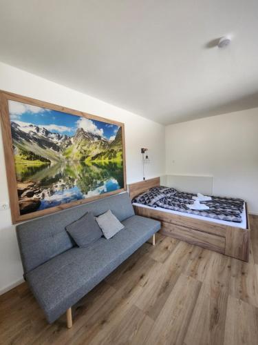 a bedroom with a couch and a large painting on the wall at Ferienwohnung Reich in Hirschegg Rein
