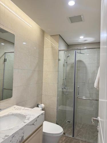 a bathroom with a shower and a toilet and a sink at Na homes coffee in Binh Hai
