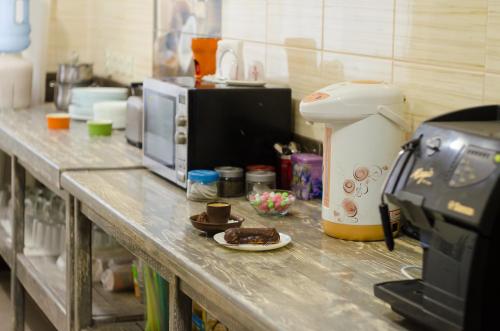 a counter in a kitchen with a microwave and a plate of food at Baron Munchausen Guest House in Kamianets-Podilskyi