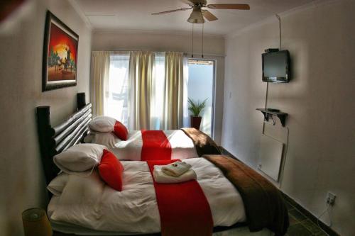 a bedroom with a large bed with a teddy bear on it at Ukarimu Guest House in Klerksdorp