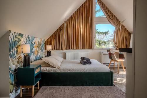 a bedroom with a bed and a desk and a window at Les Cognassiers - Studio Cosy & Equipé - Parking Gratuit - Professionnels & Familles in Illkirch-Graffenstaden