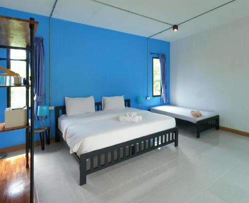 a blue bedroom with two beds in a room at Koh Kood Chalet in Ban Hin Dam
