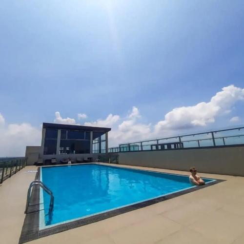 a woman sitting on the edge of a swimming pool on a building at Negombo Sea waves in Negombo
