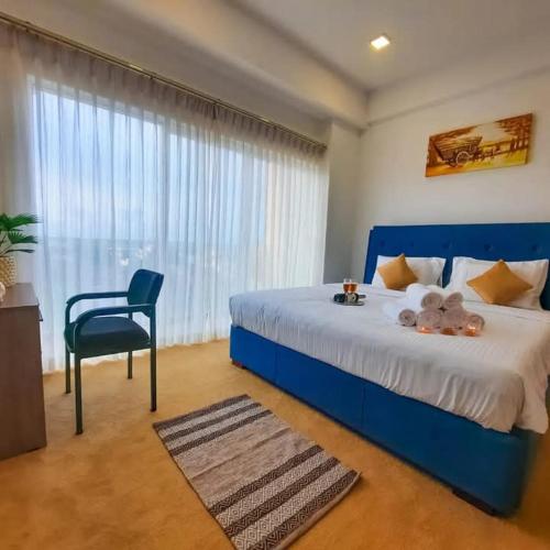 a bedroom with a blue bed and a chair at Negombo Sea waves in Negombo