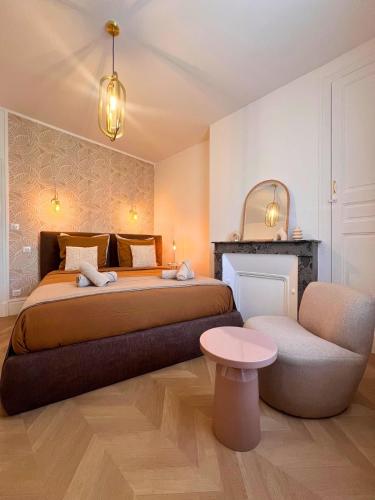 a bedroom with a large bed and a chair at Maisons Sauvages - Piscine & Jacuzzi - Proche Zoo de Beauval & Châteaux in Romorantin