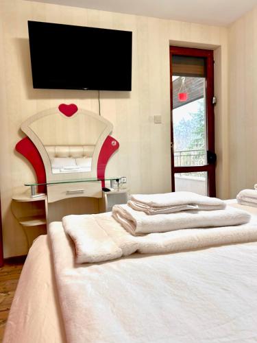 a bedroom with two beds and a flat screen tv at Villa Amity in Varna City