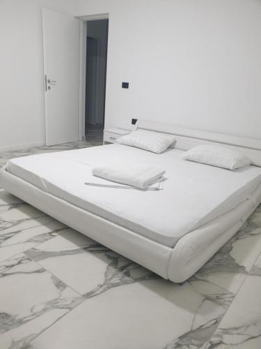 a bed in a white room with marble floors at Casa Party in Fîntînele
