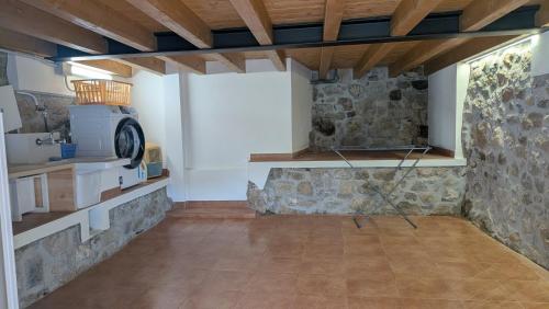 a room with a stone wall and a stove at MC Vega- Mi Casina con vistas al mar in Ribadesella
