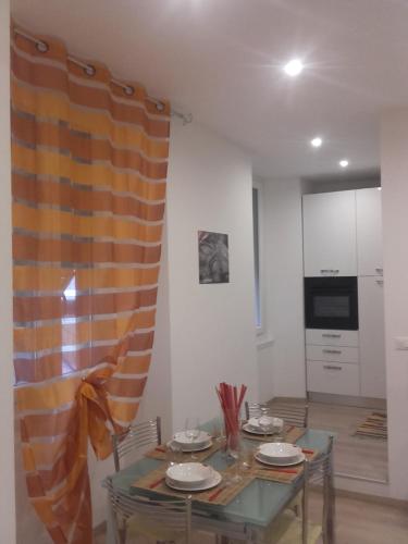 a dining room with a table and a kitchen at Alysia Apartment in Genoa
