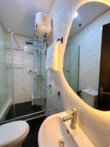 a bathroom with a shower and a sink and a toilet at NEW! 2BDR Maisonette with PS5 and balcony in Lekki phase one in Lekki