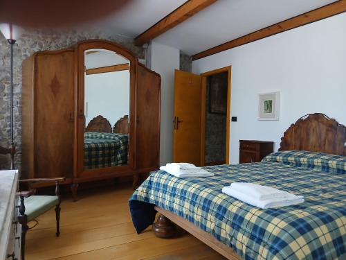 ein Schlafzimmer mit einem Bett und einem Spiegel in der Unterkunft Al Rol in Manzano