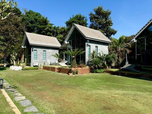 a house with a grass yard in front of it at El Vaso Resort in Chanthaburi