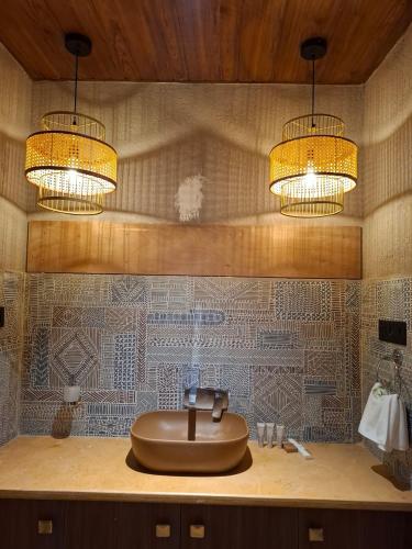 a bathroom with a sink with two lights on it at Kayo Resort Pench in Seonī