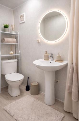 ein Badezimmer mit Waschbecken, Toilette und Spiegel in der Unterkunft Ramgon in Gonio