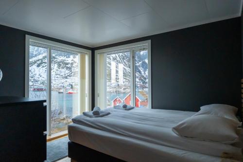 a bedroom with a large bed and two windows at Villa valen, Reine in Moskenes