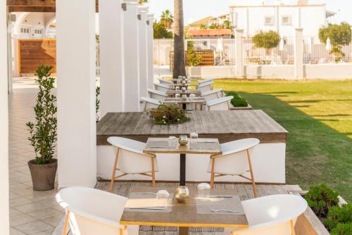 a row of tables and chairs on a patio at Ionian Blue Beach Hotel - Adults Only in Kavos