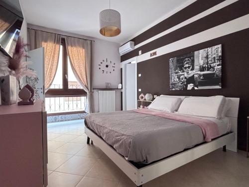 a bedroom with a large bed with a striped wall at Casa di Silvia city center in Verona