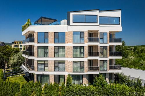 an apartment building with balconies and trees at AthmosphereVillaEma Apartments in Kranevo