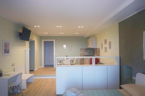 a kitchen with white cabinets and a living room at Bixio 40, Alloggio Turistico in Montefiascone