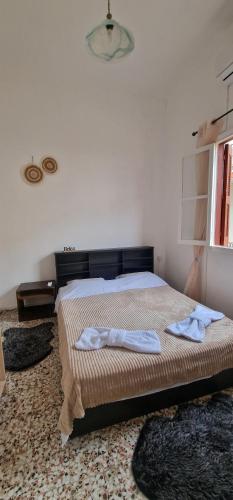 a bedroom with a bed with two towels on it at Niki's Cozy Home in Kalymnos