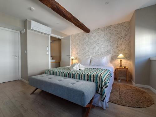 a bedroom with a bed with a bench in it at Secret Garden in Bragança - historic center in Bragança